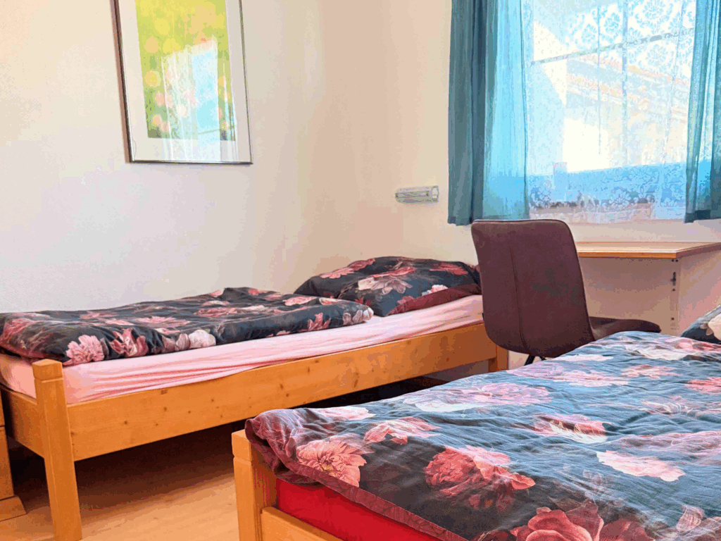 Zweites Schlafzimmer mit Fenster, Einzelbetten und Kleiderschrank