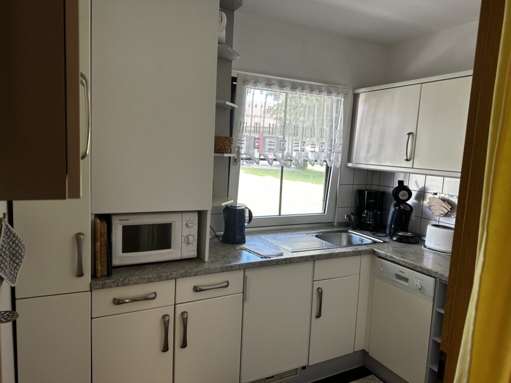 Voll ausgestattete Küche mit Spülmaschine, Backofen und Herd